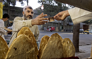 Прохожий покупает хлеб у уличного торговца. ФАО / Джулио Наполитано